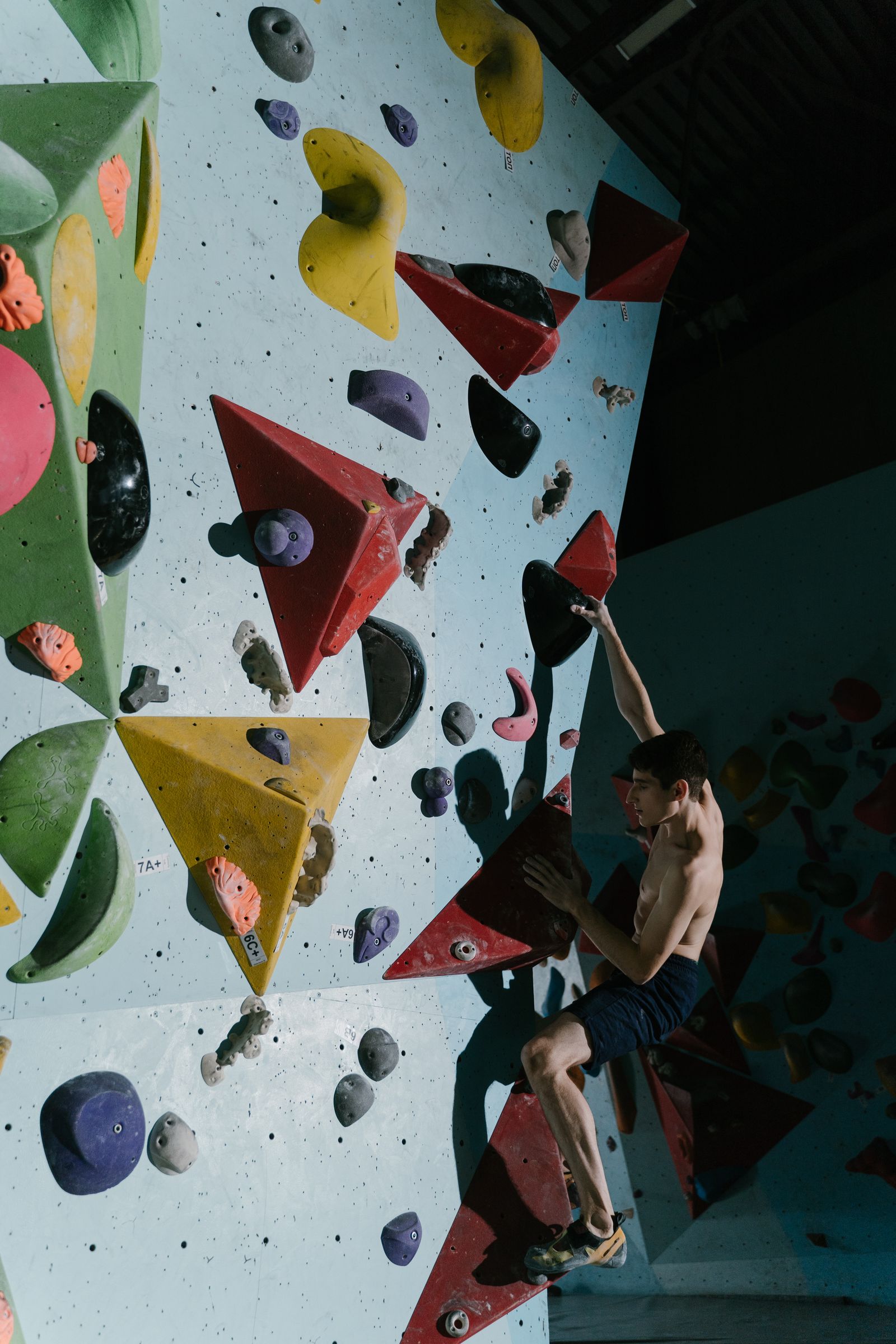 Boulderaar op een kleurrijke boulderwand — software vergelijken voor boulderhallen