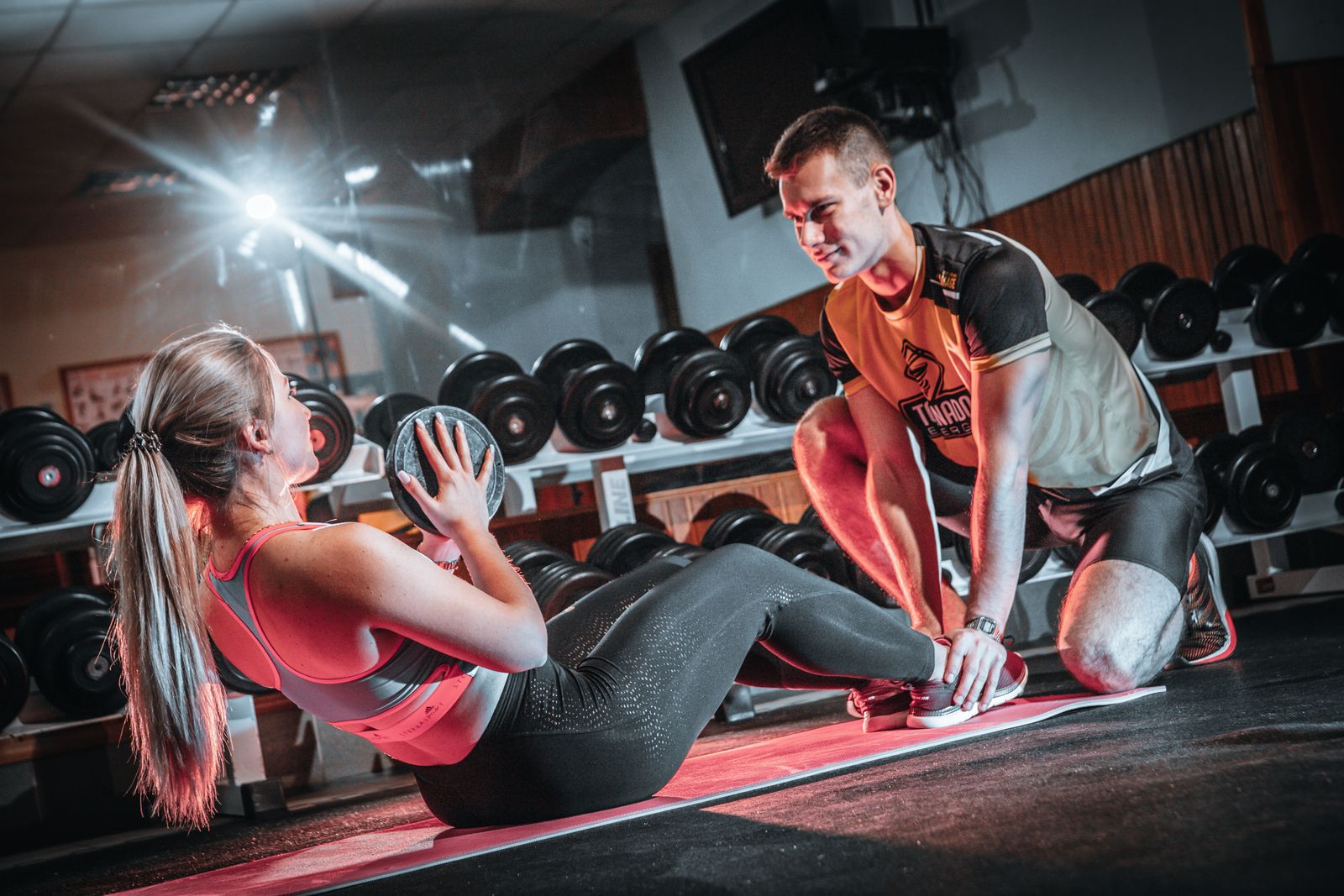 Personal trainer begeleidt een klant tijdens een 1-op-1 training in de sportschool