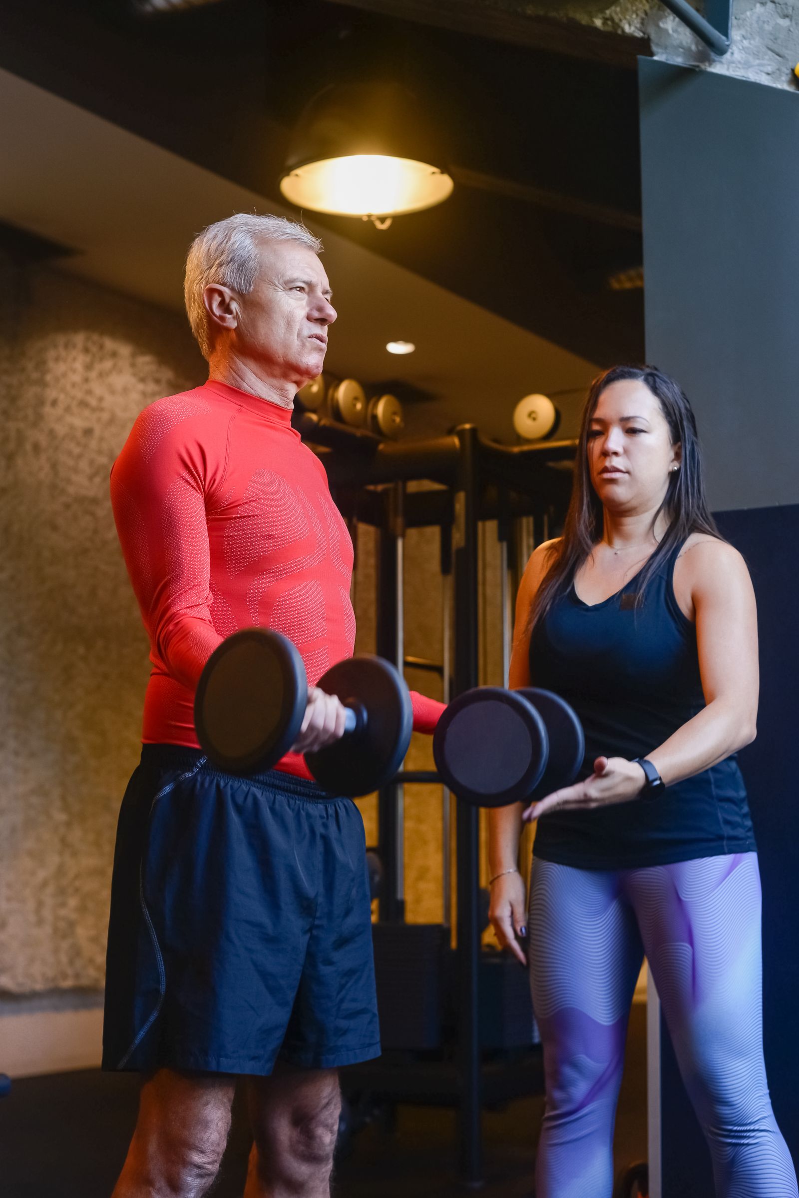 Personal trainer coacht een klant met dumbbells — de klant koos deze trainer in Planurr